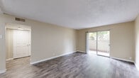 Located at 3351 Cottage Way in Arden-Arcade, California, this single-story, 2-bedroom, 1-bathroom unit offers a well-organized layout with a practical flow throughout. Dark wood-style flooring runs through the main living areas and hallways, complemented by neutral beige walls and textured ceilings that lend a clean, consistent aesthetic.

The living room is a comfortable, open space bathed in natural light, with sliding glass doors that open directly onto a private patio — ideal for indoor-outdoor living. Adjacent to the living room, the combined dining and kitchen area is thoughtfully designed, featuring white shaker-style cabinetry, granite-look countertops, a stainless steel sink, and black appliances including a gas range and full-size refrigerator. A window above the sink brings in additional natural light.

The spacious primary bedroom is carpeted for comfort and includes a ceiling fan, a window for natural light, and access to a generous closet with built-in hanging rods. The second bedroom also features carpeting and its own closet. Three closets in total provide ample storage throughout the unit.

The full bathroom offers a tub/shower combination, wood-style flooring, and a window for ventilation. Additional conveniences include a dedicated laundry area and a utility room. Two hallways connect the spaces efficiently, completing this functional and well-appointed home.