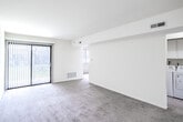 Located at 150 West Ave in Woodstown, NJ, this two-bedroom, one-bathroom residence offers a well-organized single-floor layout with a practical and comfortable flow throughout. The open living area is carpeted and bathed in natural light courtesy of a sliding glass door that opens to an outdoor view, complemented by vertical blinds. In-unit washer and dryer hookups are conveniently situated adjacent to the living space. The kitchen features rich, dark wood cabinetry extending to the upper walls, light countertops, tile flooring, and white appliances including a refrigerator, electric range, microwave, and dishwasher, with direct sightlines to the dining area. The primary bedroom is a generously sized, carpeted room with a walk-in closet equipped with built-in shelving, as well as an additional door providing hallway access. The second bedroom is carpeted and receives natural light through a window fitted with blinds. The full bathroom includes a tub-shower combination with a white surround, pink accent tiling, mosaic tile flooring, and standard fixtures. A hallway, closet, staircase, and dedicated dining room round out the layout, providing ample storage and defined living zones throughout this well-structured home.