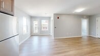 Located at 345 Chestnut St, Unit 301 in Manchester, NH, this two-bedroom, one-bathroom residence offers a thoughtfully designed single-level layout. The open-concept kitchen and living area serves as the heart of the home, featuring rich walnut-toned cabinetry, stainless steel appliances including a refrigerator, range, microwave, and dishwasher, complemented by light hardwood-style flooring that runs throughout the main living spaces. Recessed lighting and large windows fill the area with natural light, while a patio door leads to an outdoor patio with views of the surrounding streetscape. The living and dining areas flow seamlessly from the kitchen, creating a bright and functional shared space. Both bedrooms are carpeted and finished with neutral gray walls, offering a calm and comfortable atmosphere. The primary bedroom includes generous closet space, while the second bedroom is equally well-sized. Five closets throughout the unit provide ample storage. The bathroom features a tub/shower combination, wood-tone flooring, and clean, simple finishes. With its modern finishes and practical layout, this unit delivers a comfortable and contemporary living experience in the heart of Manchester.