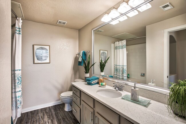 Bathroom with a large vanity mirror, large quartz counters, and a shower and tub combination. - Ellery at  Lake Sherwood