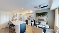 Located at 25 Windsor Circle in Newark, Delaware, this two-story, 3-bedroom, 1-bathroom home offers a thoughtfully designed layout spread across two floors. The main level opens into a bright living room with light hardwood-style flooring, neutral tones, and a large window that fills the space with natural light. Adjacent to it, the combined kitchen and dining area is a standout feature — the kitchen showcases two-tone cabinetry with sleek upper panels and dark lower cabinets, white appliances including a range and refrigerator, a subway tile backsplash, and a kitchen island with seating. An in-unit stacked washer and dryer is conveniently tucked nearby. The dining area accommodates a round table and benefits from a large window with outdoor views. Upstairs, the primary bedroom is generously proportioned, featuring a calming blue accent wall, carpeted flooring, a closet, and a bright window. Two additional bedrooms offer comfortable accommodations, one with soft blue walls and natural light. The shared bathroom is clean and minimalist, with tile flooring and efficient storage. A hallway connects the upper-level rooms, completing this functional and well-appointed home.