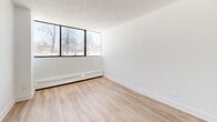 Located at 120 Torresdale Ave in Toronto, this well-appointed 2-bedroom, 1-bathroom unit offers a thoughtfully designed single-floor layout with a clean, modern aesthetic. Light wood laminate flooring runs consistently throughout the space, complementing the crisp white walls and textured ceilings to create a bright, cohesive atmosphere.

The living areas benefit from large, floor-to-ceiling windows that invite generous natural light and offer views of the surrounding tree-lined neighbourhood. Baseboard heating runs along the window walls, ensuring comfort year-round.

The kitchen features a galley-style layout with white cabinetry, grey countertops, and white subway tile backsplash — a functional and stylish space with ample counter space on both sides.

Both bedrooms are well-sized, with the primary bedroom offering a comfortable footprint. Each bedroom is equipped with mirrored sliding closet doors that enhance the sense of space and add a practical storage solution. The bedrooms connect conveniently to the hallways, providing smooth circulation throughout the unit.

The bathroom is finished with classic white subway tile surrounding a full soaker tub with a chrome shower fixture, paired with neutral floor tile for a clean, timeless look.

Two hallways provide efficient flow between rooms, and the overall layout makes excellent use of the available floor area.