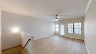Located at 3232 N Garland Ave in Garland, TX, this three-story townhome offers a well-organized layout spread across multiple levels. The ground floor provides an attached garage with an automatic opener and concrete flooring, offering secure parking and storage. Carpeted stairs with a warm wood handrail lead upward to the main living level, which serves as the heart of the home. Here, a bright and open living room features light wood-look flooring, crown molding, a ceiling fan with light fixture, and large windows with a glass door that invite abundant natural light. The adjacent kitchen is equipped with stainless steel appliances — including a refrigerator, range, and microwave — complemented by granite-look countertops, gray shaker-style cabinetry, and matching light flooring. The upper floor hosts two bedrooms, including a generously sized primary bedroom with vaulted ceilings, a ceiling fan, crown molding, and a natural light-filled window. The second bedroom also features vaulted ceilings and a bright window. Two full bathrooms, including one with a tiled tub-shower combo and granite-accented vanity, serve the upper level. Three closets provide ample storage throughout the home.