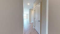 This thoughtfully designed single-floor unit offers a clean, contemporary aesthetic throughout, characterized by warm wood-look flooring, neutral wall tones, and crisp white trim that create a cohesive and inviting atmosphere.

The open-concept kitchen serves as a central hub, outfitted with white shaker-style cabinetry reaching to the ceiling, granite countertops, stainless steel appliances including a refrigerator, range, and microwave, and a generous central island. Pendant lighting and a track light fixture add both function and style above the workspace. The kitchen flows seamlessly into the living area, which is bathed in natural light from a set of large, floor-to-ceiling windows that frame views of the surrounding neighborhood and greenery.

The bedrooms are well-proportioned, each featuring wood-look flooring, neutral walls, and white panel doors. One bedroom benefits from abundant natural light through a large window with tree-lined views, while another includes dual closets for ample storage.

The bathrooms are finished with tasteful details, including tile flooring, white subway-tiled tub-shower combinations with curved curtain rods, white vanity cabinetry, and granite countertops. A connecting hallway with recessed lighting and a panel door provides smooth transitions between spaces, completing this well-planned and modern layout.