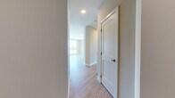 This thoughtfully designed single-floor unit offers a clean, contemporary aesthetic throughout, characterized by warm wood-look flooring, neutral wall tones, and crisp white trim that create a cohesive and inviting atmosphere.

The open-concept kitchen serves as a central hub, outfitted with white shaker-style cabinetry reaching to the ceiling, granite countertops, stainless steel appliances including a refrigerator, range, and microwave, and a generous central island. Pendant lighting and a track light fixture add both function and style above the workspace. The kitchen flows seamlessly into the living area, which is bathed in natural light from a set of large, floor-to-ceiling windows that frame views of the surrounding neighborhood and greenery.

The bedrooms are well-proportioned, each featuring wood-look flooring, neutral walls, and white panel doors. One bedroom benefits from abundant natural light through a large window with tree-lined views, while another includes dual closets for ample storage.

The bathrooms are finished with tasteful details, including tile flooring, white subway-tiled tub-shower combinations with curved curtain rods, white vanity cabinetry, and granite countertops. A connecting hallway with recessed lighting and a panel door provides smooth transitions between spaces, completing this well-planned and modern layout.