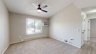Located at 923 Maplewood Dr in Cedar Falls, Iowa, this 2-bedroom, 1-bathroom unit offers a practical and comfortable single-floor layout. The kitchen is a standout feature, showcasing crisp white cabinetry, light wood-look vinyl flooring, and a full suite of black appliances including a refrigerator, dishwasher, and range. Ample counter space and a built-in sink make the kitchen both functional and visually clean.

Both bedrooms are carpeted and bathed in natural light through large windows with blinds, offering pleasant outdoor views of the surrounding neighborhood. The primary bedroom includes a ceiling fan with integrated lighting and a wall-mounted air conditioning unit, while the second bedroom features a spacious sliding-door closet. Baseboard heating is present throughout the unit.

The bathroom is finished with light wood-look flooring, a white vanity with a modern black-hardware faucet, a large mirror, and a full tub-shower combination. The neutral, light gray tones carried throughout each room give the unit a cohesive, clean aesthetic. The thoughtful layout, as seen in the dollhouse overview, provides efficient use of the available space while maintaining clear separation between living areas.