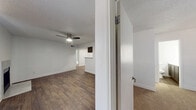 This single-floor, 2-bedroom, 2-bathroom residence offers a practical and comfortable layout designed for everyday living. The open-concept living room features rich dark hardwood-style flooring, a ceiling fan with light fixture, and a textured ceiling, creating a bright and airy atmosphere. A pass-through breakfast bar connects the living area seamlessly to the kitchen, which is well-equipped with dark gray cabinetry, striking white marble-style quartz countertops, stainless steel appliances, and recessed lighting — a clean, modern aesthetic throughout.

Both bedrooms are carpeted for comfort and feature neutral white walls and textured ceilings. The primary bedroom offers a sliding glass door with vertical blinds, a ceiling fan, and hardwood-style flooring. The second bedroom includes a window with blinds that allows natural light to fill the space. Each bedroom is supported by its own closet for ample storage.

The bathrooms echo the kitchen's design language, featuring matching gray vanity cabinetry and quartz countertops paired with a large mirror. A dedicated in-unit laundry room with shelving adds convenience to the layout. The overall design presents a cohesive, move-in ready space with consistent modern finishes throughout.