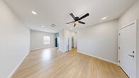 This single-story, 3-bedroom, 1-bathroom home offers a clean, modern aesthetic with a thoughtfully organized layout. Throughout the home, light wood-style flooring creates a bright and cohesive look, complemented by crisp white walls and white baseboards that enhance the sense of openness.

The living room is a comfortable, airy space featuring recessed lighting and a ceiling fan, making it both functional and inviting. Adjacent to it, the dining area provides a natural flow for everyday living. The kitchen is a standout feature, outfitted with stylish powder-blue shaker cabinetry, dark countertops, and stainless steel appliances including a refrigerator, gas range, and built-in microwave. A window above the counter allows natural light to fill the space.

The three bedrooms are well-proportioned, each equipped with a ceiling fan and access to closets. The primary bedroom is notably spacious, with recessed lighting and an open, versatile layout. The shared full bathroom is finished with a blue vanity, dark countertop, an undermount sink, and a tub-shower combination with brushed nickel fixtures. Additional conveniences include a dedicated laundry area and a hallway connecting the home's rooms efficiently.