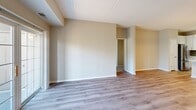 Located at 1155 Museum Blvd in Vernon Hills, IL, this three-bedroom, two-bathroom residence offers a well-designed single-floor layout with a thoughtful blend of modern finishes and functional living spaces. The open-concept kitchen and living area serves as the heart of the home, featuring a central island with a stainless steel sink, white cabinetry, quartz countertops, a tile backsplash, and stainless steel appliances including a refrigerator, range, microwave, and dishwasher. A stylish pendant light anchors the kitchen, while track lighting adds warmth overhead. The living room is bathed in natural light from large sliding glass doors that open onto a private balcony with outdoor views. Wood-look plank flooring flows throughout the main living areas, complementing the neutral, warm-toned walls. The three bedrooms offer plush carpeting, natural light from windows, and clean panel doors. The primary bedroom includes a well-organized walk-in closet with built-in shelving and drawers. Both bathrooms are finished with white cabinetry, quartz vanity tops, large framed mirrors, and wood-look flooring. The primary bath features a double-sink vanity and a full soaking tub with shower. A hallway and two closets round out this efficiently designed home.