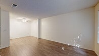 Located at 881 Soft Wind Rd in Vista, California, this single-floor residence offers a clean, functional layout with a neutral palette throughout. The open living areas are finished with warm wood-style laminate flooring that extends through the main spaces, complemented by textured ceilings and crisp white walls. Natural light filters in through vertical-blind-covered windows, offering views of surrounding greenery. The living area is spacious and versatile, with a ceiling fan providing additional comfort. The galley-style kitchen is efficiently arranged with white cabinetry lining both sides, offering ample storage, along with a range, dishwasher, refrigerator, and a stainless steel sink beneath overhead task lighting. The bedrooms are carpeted for comfort and each feature ceiling fans and window access to natural light. One bedroom includes a generously sized walk-in closet with built-in shelving on multiple walls. The bathroom is finished in white, featuring a combined tub and shower, a vanity with cabinet storage, and a large mirror. The entry area includes a wall-mounted HVAC unit and a paneled front door. This well-maintained, move-in-ready residence presents a straightforward and practical living environment in a desirable Vista location.