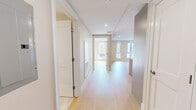 Located at 105 Washington St in Boston, MA, this well-designed two-bedroom, one-bathroom residence offers a thoughtful layout with modern finishes throughout. Light-toned hardwood flooring runs continuously across the entire space, lending a clean, cohesive aesthetic to every room.

The open-concept kitchen and living area serves as the heart of the home. The kitchen is outfitted with a large central island featuring a white quartz countertop and an undermount sink, complemented by sleek white cabinetry, a subway tile backsplash, and a full suite of stainless steel appliances including a gas range, microwave, and French door refrigerator. Pendant lighting above the island adds both function and style.

A bright hallway connects the living area to the two bedrooms. The primary bedroom is a well-proportioned retreat with dual windows offering views of the surrounding urban streetscape and recessed lighting overhead. The second bedroom is a comfortable, versatile space with its own window and ceiling fixture. Both rooms feature clean neutral walls and generous proportions.

Storage is well-addressed with two closets equipped with adjustable shelving systems and hanging rods. The full bathroom includes a tub-shower combination with a curved curtain rod, recessed lighting, and crisp white finishes. The entire residence reflects a modern, move-in-ready sensibility with a neutral palette throughout.