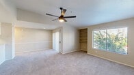 Located in Scottsdale, Arizona, this single-floor, 2-bedroom, 1-bathroom residence offers a well-designed layout with a comfortable and functional living environment. The open-concept kitchen and living area form the heart of the home, with the kitchen featuring white shaker-style cabinetry, granite-look countertops, stainless steel appliances including a range, over-the-range microwave, and refrigerator, plus wood-look flooring that adds warmth to the space. The living area flows naturally from the kitchen and is finished with plush carpeting throughout.

The spacious primary bedroom is a standout feature, boasting vaulted ceilings, a ceiling fan, built-in shelving, and a sliding door leading to a private patio with views of surrounding greenery. A generous walk-in closet with built-in shelving and hanging rods provides ample storage. The second bedroom is well-proportioned, carpeted, and includes a ceiling fan and a window that lets in natural light. A total of three closets throughout the unit ensure abundant storage. The full bathroom completes this thoughtfully arranged home, making it an ideal residence in the heart of Scottsdale.