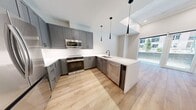This contemporary 650 square foot apartment in Denver offers a harmonious blend of style and functionality. The heart of the home is a modern kitchen, showcasing sleek grey cabinetry, stainless steel appliances, and a striking white quartz countertop. Pendant lighting adds a touch of elegance, while the open concept layout seamlessly connects to the living area.

The spacious bathroom features a glass-enclosed shower with white tiled walls, a floating vanity, and modern fixtures. The bedroom, measuring 160 square feet, provides ample space and includes a closet for storage. Throughout the apartment, warm wood-look flooring creates a welcoming atmosphere and contrasts beautifully with the crisp white walls.

Large windows in the living area and bedroom flood the space with natural light and offer urban views, enhancing the sense of openness. The apartment's design emphasizes clean lines and a neutral color palette, creating a canvas for personal style. With its thoughtful layout and high-end finishes, this apartment epitomizes modern urban living in the heart of Denver.