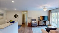 Located at 4632 Still Meadow Dr in Wilmington, NC, this thoughtfully designed 2-bedroom, 2-bathroom single-floor residence offers a comfortable and functional layout. The open-concept living, dining, and kitchen area serves as the heart of the home, featuring durable wood-style flooring, recessed lighting, and a ceiling fan. The kitchen is outfitted with gray shaker cabinets, granite countertops, stainless steel appliances, and a peninsula that connects seamlessly to the dining space. Sliding glass doors in the living room open to a private balcony, filling the space with natural light and providing outdoor views. The primary bedroom offers plush carpeting, a ceiling fan, a natural light-filled window with outdoor views, and access to a spacious walk-in closet with wire shelving. The second bedroom is equally comfortable, featuring carpet flooring, a ceiling fan, and a bright window. Both bathrooms are finished with granite-topped vanities and wood-style flooring; one includes a full tub-shower combination. Additional highlights include five closets for ample storage, a dedicated laundry area, and a hallway connecting all rooms efficiently. The overall ambiance is bright, coastal-inspired, and move-in ready.