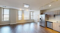 Located at 272 E Main St in the heart of downtown Rochester, NY, this thoughtfully designed 2-bedroom, 3-bathroom unit offers a well-appointed, modern living experience across a single floor. The open-concept kitchen and living area serves as the centerpiece of the home, featuring stainless steel appliances including a refrigerator, gas range, and built-in microwave, complemented by light wood-grain cabinetry, white quartz countertops, and a classic subway tile backsplash. Track lighting illuminates the space, which flows seamlessly into the living area over warm hardwood-style flooring. Both bedrooms are generously sized, with the primary bedroom offering notable square footage, large windows with city views, and ample natural light. The second bedroom also features wide windows overlooking the Rochester skyline. All three bathrooms are finished with clean, contemporary tile work, including walk-in glass-enclosed showers with large-format white subway tile surround and mosaic tile flooring. A dedicated closet and in-unit laundry area add practical convenience. The neutral color palette, modern finishes, and abundant natural light throughout create a bright, cohesive ambiance well-suited to urban living.