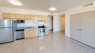 This single-floor unit offers a well-designed layout that balances functionality and comfort. The open kitchen is equipped with stainless steel appliances, including a refrigerator, electric range, built-in microwave, and dishwasher. Light maple cabinetry provides ample storage, while granite-style countertops add a polished finish. The kitchen flows naturally into the main living area, which features light hardwood-style flooring, a ceiling fan, and large windows that invite abundant natural light and offer views of the surrounding urban landscape.

The bedrooms are comfortably sized, each featuring the same light flooring, windows with outdoor views, and light-toned doors. The clean, neutral walls create a bright and versatile atmosphere throughout.

The unit includes two bathrooms. The full bathroom is outfitted with a bathtub and shower combination, a single-sink vanity with maple cabinetry, a white countertop, and a mirror with overhead lighting, complemented by a drop tile ceiling. The second bathroom features a standalone shower, a matching vanity setup, and a well-lit mirror, maintaining a consistent, clean aesthetic. Vinyl flooring in both bathrooms ensures durability and easy maintenance. Overall, the unit presents a modern, practical living space with a cohesive design throughout.
