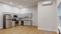 Located at 501 State St in Schenectady, NY, this thoughtfully designed one-bedroom, one-bathroom unit offers a clean, modern aesthetic throughout its efficiently laid-out single floor. The open-concept kitchen and living area serves as the heart of the unit, featuring light wood luxury vinyl plank flooring, crisp white walls, and recessed lighting that creates a bright and welcoming atmosphere. The kitchen is outfitted with gray shaker-style cabinetry, granite-look countertops, a stainless steel refrigerator, range, microwave, and dishwasher — providing a fully equipped cooking space. A wall-mounted mini-split unit provides climate control throughout. Natural light enters through multiple windows fitted with blinds, adding warmth to the living space. The bedroom offers a comfortable footprint with its own mini-split unit for individual climate control and direct access to a dedicated walk-in closet featuring wire shelving for organized storage. The full bathroom is finished with large-format gray tile flooring and includes a bathtub/shower combination. Clean lines, neutral tones, and quality finishes give the entire unit a polished, move-in-ready feel.
