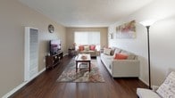 Located in the Arbor Park community of Long Beach, California, this single-floor residence offers a well-designed layout that balances comfort and functionality. The living room is a welcoming space highlighted by rich hardwood-style flooring, neutral warm-toned walls, and a textured ceiling. A large window with vertical blinds allows natural light to fill the room, complementing the open, airy feel. A wall-mounted AC unit provides climate control throughout.

The galley-style kitchen is efficiently designed with white cabinetry, granite-look countertops, and white appliances including a gas range and refrigerator. The hardwood-style flooring continues here, adding visual continuity throughout the home.

The bedroom features plush carpeting, a ceiling fan with light fixture, and a generously sized window that brings in soft, diffused light. Warm beige walls and ample space create a restful and comfortable retreat.

The bathroom is clean and functional, featuring a granite-look vanity countertop, a tub-shower combination, and hardwood-style flooring that ties back to the rest of the home's aesthetic. The overall ambiance of this residence is warm, neutral, and move-in ready, making it a practical and comfortable home in a desirable Long Beach neighborhood.