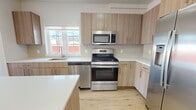 This contemporary 1-bedroom apartment in Bogota, NJ offers 570 square feet of efficiently designed living space. The open floor plan creates a seamless flow between the living areas, enhancing the sense of spaciousness. The primary bedroom, measuring 130 square feet, provides ample space for rest and relaxation.

The kitchen is a standout feature, boasting modern wood-grain cabinetry, sleek stainless steel appliances, and a pristine white quartz countertop. A central island adds extra prep space and casual dining options. Large windows in both the kitchen and bedroom flood the spaces with natural light, while offering views of the surrounding area.

The bathroom exudes a spa-like ambiance with its neutral color palette, featuring a wood vanity with double sinks, a large mirror, and a shower-tub combination with curved glass doors. Throughout the apartment, light wood flooring adds warmth and continuity to the space.

With its thoughtful design and high-quality finishes, this apartment offers a perfect blend of style and functionality for modern urban living.