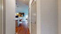 This single-story residence is thoughtfully designed with a contemporary aesthetic and practical layout. A welcoming entry hallway with warm hardwood-style flooring leads into the open-concept living and dining area, where large sliding glass doors flood the space with natural light and provide direct access to a private balcony overlooking green outdoor surroundings.

The kitchen is well-equipped with sleek, flat-front cabinetry in a warm wood-tone finish, granite countertops, a white tile backsplash, and a full suite of stainless steel appliances. A peninsula counter extends the workspace and provides casual seating. Pendant lighting accents the area, adding a modern touch.

Both bedrooms are generously sized, featuring ceiling fans, multiple windows with outdoor views, and plush carpeted floors. Each is served by its own bathroom finished with granite-topped vanities, wood-tone cabinetry, large mirrors, and tub-shower combinations. A dedicated laundry room with a full-size washer and dryer adds everyday convenience.

Throughout the residence, consistent hardwood-style flooring, neutral wall tones, and modern fixtures create a cohesive, contemporary ambiance.
