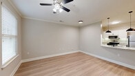 Located at 5817 Garden Village Ct in Greensboro, NC, this efficiently designed single-floor residence offers a well-organized layout comprising one bedroom, one bathroom, a kitchen, a garage, a utility room, and a closet. The living area features light hardwood-style flooring, neutral gray walls, crown molding, and a ceiling fan, creating a clean and comfortable atmosphere. The kitchen is thoughtfully appointed with white cabinetry, granite countertops, light tile flooring, and a full suite of stainless steel appliances including a gas range, microwave, and refrigerator. The bedroom is carpeted for warmth and comfort, includes a ceiling fan, and benefits from a window that invites natural light and outdoor views. The bathroom offers a granite-topped vanity with dark wood cabinetry, a full tub-shower combination, and light wood-style flooring. A dedicated closet provides convenient storage adjacent to the bedroom. The attached garage features a roll-up door and overhead fluorescent lighting, offering practical parking and additional storage space. A utility room rounds out the functional layout of this well-maintained Greensboro home.