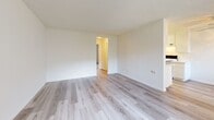 Located at 3534 W Ball Rd in Anaheim, California, this single-story, one-bedroom, one-bathroom unit offers a functional and efficiently organized layout. The living room serves as the central gathering space, featuring light gray laminate wood flooring, neutral cream-toned walls, a textured ceiling, and a front-facing window that allows natural light to filter in. The room connects to a hallway that leads to the remaining areas of the unit.

The galley-style kitchen runs parallel along two walls, outfitted with white upper and lower cabinetry providing ample storage, white laminate countertops, a stainless steel sink, and a white electric range. Overhead fluorescent lighting ensures the kitchen remains well-lit throughout the day.

The spacious primary bedroom is carpeted and includes a window overlooking the exterior. It opens directly into a dedicated vanity area featuring a wide mirror, built-in countertop with drawers, and lighted fixtures—offering a functional dressing space. Two closets provide generous storage throughout the unit.

The bathroom includes a full-size soaking tub with a shower combination, finished with clean white surroundings. A hallway connects all rooms, contributing to an efficient and cohesive floor plan throughout the unit.