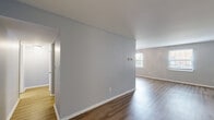 Located at 5521 Chatford Square in Columbus, Ohio, this single-floor, 2-bedroom, 1-bathroom home offers a practical and comfortable layout. The spacious living room serves as the heart of the home, featuring warm wood-style laminate flooring, soft neutral gray walls, and two windows that allow generous natural light to fill the space. A ceiling fan adds year-round comfort to this generous gathering area.

The galley-style kitchen is efficiently designed with white cabinetry lining both sides, dark countertops, a stainless steel sink, and black appliances including an electric range and refrigerator. A connecting hallway links the kitchen to the rest of the home seamlessly.

Both bedrooms are carpeted and finished with the same soft gray tones seen throughout the home. The primary bedroom is a well-proportioned retreat, featuring two windows with blinds that invite in outdoor views and natural light. The second bedroom also benefits from a window and includes a sliding-door closet for convenient storage.

The full bathroom is equipped with a tub-shower combination, tile accents, and brushed nickel fixtures and grab bars. Clean white finishes keep the space feeling fresh and functional. Throughout the home, white trim and baseboards provide a crisp contrast to the light gray walls, lending a cohesive and tidy aesthetic.