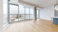 Located at 929 Richmond Rd in Ottawa's vibrant west end, this well-appointed one-bedroom, two-bathroom unit offers a thoughtfully designed open-concept layout finished with light hardwood flooring and crisp white walls throughout. The combined kitchen and living area forms the heart of the unit, where a sleek, modern kitchen showcases grey flat-panel cabinetry with gold hardware, a herringbone tile backsplash, stainless steel appliances, and a central island with an integrated breakfast bar — all illuminated by stylish pendant lighting. The expansive living room is defined by dramatic floor-to-ceiling windows that wrap the space, framing sweeping panoramic views of the Ottawa skyline and surrounding neighbourhood while flooding the interior with abundant natural light. A distinctive exposed concrete column adds an architectural accent to the living area. The bedroom is a comfortable, private retreat, also benefiting from large windows with outdoor views. Two well-appointed bathrooms feature clean, contemporary finishes, including white subway tile, hexagonal mosaic floor tile, chrome fixtures, a soaker tub, and a separate glass-enclosed walk-in shower. A dedicated closet and hallway complete the functional layout of this bright, modern urban residence.