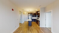 Located at 145 Monmouth St in the heart of Red Bank, NJ, this thoughtfully designed single-floor residence offers a cohesive blend of modern finishes and functional living spaces. The kitchen serves as the centerpiece of the home, showcasing rich dark-espresso cabinetry with brushed nickel hardware, stainless steel appliances including a gas range, microwave, refrigerator, and dishwasher, complemented by crisp white countertops and a subway tile backsplash. A central island provides additional prep space and casual seating, while warm hardwood-style flooring and an elegant chandelier add polish and character to the area. The bedrooms are finished with plush wall-to-wall carpeting and neutral tones, offering a calm and comfortable retreat. Natural light filters in through windows fitted with blinds, and each bedroom includes closet storage with built-in shelving. The primary bathroom features a glass-enclosed shower stall, a dark-cabinetry vanity with a white countertop, and tile flooring, while the second bathroom offers a full soaking tub with a tiled surround and similar refined finishes. Clean white trim, recessed lighting, and a consistent neutral palette throughout the unit create a bright, move-in-ready atmosphere ideal for comfortable everyday living in vibrant Red Bank.