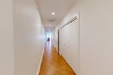 Located in the heart of downtown Syracuse, this generously sized 2-bedroom, 2-bathroom residence offers a thoughtfully designed single-floor layout. The open-concept kitchen and living area serves as the central hub of the home, featuring rich cherry wood cabinetry, stainless steel appliances, a granite-topped island with pendant lighting, and warm hardwood floors — all complemented by large windows that invite abundant natural light and urban views.

A long, elegant hallway with herringbone-patterned hardwood flooring connects the living space to the private quarters, lined with multiple closets offering exceptional storage. The spacious primary bedroom boasts an ornate coffered ceiling, hardwood floors, and large windows overlooking the city skyline. Bedrooms are carpeted for comfort and include generous closet space with built-in rods.

The primary bathroom is a bright, spa-like retreat featuring large-format tile flooring, a glass-enclosed shower, granite double vanity with white cabinetry, and direct access to the bedroom. A dedicated in-unit laundry room with washer and dryer adds everyday convenience. The residence combines historic architectural character with modern finishes for a distinctive urban living experience.