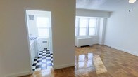This single-floor space is divided into two distinct areas visible from a central vantage point. The living area is bathed in natural light streaming through double-pane windows framed by classic white molding, illuminating the glossy, herringbone-patterned parquet hardwood floors below. A white radiator sits beneath the windows, suggesting a traditional heating system consistent with older building construction. The walls are finished in a clean, neutral white throughout, contributing to a bright and airy atmosphere.

The separate kitchen, accessible through a doorway, features a striking black-and-white checkered tile floor that adds a timeless, retro aesthetic. The kitchen is equipped with a white gas range and matching white cabinetry, and benefits from its own window, allowing for natural light and ventilation. A radiator is also present in the kitchen, maintaining consistent heating throughout the unit.

The overall design reflects classic pre-war architectural details, combining durable, vintage-style finishes with functional layouts. The polished floors and abundant natural light give the space a well-maintained and inviting character.