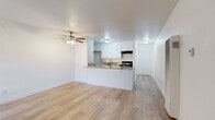 Located at 6702 Vineland Ave in North Hollywood, Los Angeles, this efficiently designed single-floor unit offers a thoughtfully arranged layout that maximizes every square foot. The open-plan kitchen and living area form the heart of the space, unified by warm light wood-look flooring that runs throughout. The living area is bright and airy, featuring a ceiling fan, a wall-mounted A/C unit, and a sliding glass door that invites natural light and provides outdoor access. A built-in wall heater adds a practical touch to the clean, white-painted walls. The kitchen is defined by a peninsula with striking granite countertops that extend into a breakfast bar, offering both prep space and casual seating. White shaker-style cabinetry lines the walls above and below, complemented by a black gas range with an overhead exhaust hood and a stainless steel sink. The bathroom continues the cohesive design language with a white vanity topped with granite, wood-look flooring, and a full soaking tub with white tile surround. A dedicated closet provides additional storage. The overall aesthetic is clean, modern, and functional—ideal for those seeking a well-appointed space in the North Hollywood neighborhood of Los Angeles.
