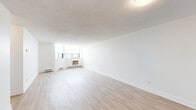 Located at 190 Lees Ave in Ottawa's Glebe-Riverside neighbourhood, this two-bedroom, two-bathroom unit offers a clean, modern interior spread across a single floor. Light wood laminate flooring runs throughout, complementing the crisp white walls and creating a bright, cohesive aesthetic.

The spacious living room is a standout feature, benefiting from corner windows that allow generous natural light and provide open city views. Baseboard heating and a wall-mounted air conditioning unit ensure year-round comfort. A dedicated hallway connects the living area to the rest of the unit, providing a clear and functional layout.

The kitchen is well-appointed with white cabinetry, dark countertops, a subway tile backsplash, and stainless steel appliances including a refrigerator, electric range, and over-the-range microwave. The two bedrooms are comfortably sized, with the primary bedroom featuring a sliding-door closet. Both bathrooms are finished with tile flooring, vanity cabinetry, and baseboard heating. Throughout the unit, the consistent use of neutral tones and updated finishes contributes to a clean, move-in-ready atmosphere.