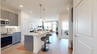 This well-appointed one-bedroom, one-bathroom residence at 2201 Clinton St in Aurora, Colorado offers a thoughtfully designed open-concept layout that maximizes every inch of its comfortable footprint. The kitchen is a standout feature, showcasing sleek gray shaker-style cabinetry reaching to the ceiling, granite countertops, a full suite of stainless steel appliances, a white subway tile backsplash, and a central island with pendant lighting and bar seating — ideal for casual dining or entertaining. The kitchen flows seamlessly into the living area, which is bathed in natural light from large windows and a glass door leading to a private balcony with open outdoor views. Light wood-style flooring runs throughout the main living space, adding warmth and continuity. The bedroom is a serene retreat, featuring plush carpet, a ceiling fan, a generous window with exterior views, and access to a dedicated closet. The bathroom is finished with granite countertops, gray cabinetry, and a full soaking tub with large-format dark tile surround. Throughout the residence, a clean, modern aesthetic is maintained with crisp white walls, recessed lighting, and contemporary finishes that create a bright, inviting ambiance.