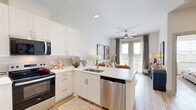 Located at 2101 S Celina Pkwy in Celina, TX, this well-designed one-bedroom, one-bathroom residence offers a thoughtfully utilized single-floor layout with a bright, contemporary aesthetic. Light wood-tone flooring flows throughout, tying together each space with a clean, cohesive look.

The open-concept kitchen and living area serves as the heart of the home. The kitchen is outfitted with white shaker cabinetry, a light quartz peninsula with bar seating, stainless steel appliances including a French door refrigerator and dishwasher, and a subtly textured tile backsplash. The peninsula opens directly to the living area, fostering a connected and social atmosphere. The living room receives generous natural light through large windows and French doors, which frame outdoor views and fill the space with warmth throughout the day.

The bedroom is a comfortable retreat, featuring a ceiling fan, natural light from a wide window with blinds and draping curtains, and easy access to the dedicated closet. The bathroom is finished with a wide white vanity, quartz countertop, and a glass-enclosed walk-in shower with tile surround and wood-look flooring, presenting a clean and modern design.

Throughout, the residence maintains a neutral, warm palette that enhances the sense of openness, making it an inviting and functional home in the growing Celina community.