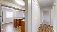 Located in Columbus, OH, this two-bedroom, two-bathroom residence offers a well-organized single-floor layout designed for comfortable everyday living. The kitchen is a functional highlight, featuring warm honey-toned cabinetry, granite-style countertops, stainless steel appliances including a refrigerator and dishwasher, and wood-look vinyl flooring that extends through the common areas. A pass-through opening connects the kitchen to the adjacent living area, promoting an open and connected feel. A large built-in closet with bifold doors provides generous hallway storage. The primary bedroom is notably spacious, featuring plush carpeting, neutral toned walls, and a wide bank of windows fitted with blinds that allow for ample natural light and outdoor views. The second bedroom also offers carpeted floors, a window with blinds, and a clean, versatile layout. Both bathrooms are clean and straightforward, with one featuring a full tub-shower combination accented by classic white square tile. The overall aesthetic throughout the residence is neutral and move-in ready, with consistent light-toned walls, white trim, and a cohesive design that provides a blank canvas for personalization.