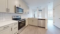 Located at 2314 Berryhill Rd in Charlotte, NC, this one-bedroom, one-bathroom unit offers a thoughtfully designed layout that maximizes every square foot. Light wood-style luxury vinyl plank flooring runs throughout, complementing the crisp white walls and modern black hardware found across the space.

The kitchen is a functional standout, featuring shaker-style cabinetry in a soft gray-white tone, white quartz countertops, a herringbone tile backsplash, and a full suite of stainless steel appliances including a range, over-the-range microwave, dishwasher, and refrigerator. The peninsula layout allows for efficient workflow and connects the kitchen to the main living area.

The bedroom is a comfortable, well-proportioned space with a ceiling fan, a window fitted with blinds for natural light control, and clean white walls. A dedicated closet provides practical storage. The entryway features three panel-style doors with black hardware, offering a clean and organized transition into the unit.

The bathroom includes a full tub-shower combo with classic white subway tile surround, wood-style flooring, and a clean, minimalist design. Recessed lighting and a neutral palette keep the space feeling open and fresh. Overall, the unit presents a modern, move-in-ready aesthetic in a compact yet efficient footprint.