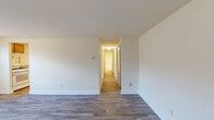 Located at 1114 Tace Drive in Essex, Maryland, this single-floor, one-bedroom unit offers a practical and efficiently designed layout. The space features consistent hardwood-style vinyl flooring throughout, lending a clean and cohesive aesthetic to every room.

The living room is bright and open, with neutral-toned walls and a large window that allows natural light to fill the space. It connects seamlessly to the kitchen, creating an easy flow for everyday living.

The kitchen is well-equipped and functional, featuring warm-toned wooden cabinetry—both upper and lower—paired with a gray countertop. White appliances, including a gas range, dishwasher, refrigerator, and microwave, are all included. A window above the sink brings in additional natural light, and the generous floor space allows for comfortable movement and use.

The bedroom offers a comfortable, private retreat with ample floor area, neutral walls, and a closet with a sliding door. A window provides natural light and ventilation, while clean white baseboards frame the room neatly.

Overall, the unit presents a straightforward, move-in-ready interior with a light, neutral palette and practical finishes throughout, suited for those seeking a manageable and functional living space in the Essex area.
