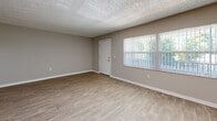 Located at 1699 68th St N in Saint Petersburg, Florida, this single-story, 3-bedroom, 2-bathroom home offers a clean and functional layout designed for comfortable everyday living. Light-toned luxury vinyl plank flooring runs consistently throughout, tying the spaces together with a fresh, modern feel. Textured ceilings and ceiling fans are present in the living areas and all bedrooms, contributing to the home's practical Florida-friendly design. The spacious living room features large windows with vertical blinds that invite abundant natural light and offer views of the lush greenery outside. The galley-style kitchen is well-appointed with white cabinetry, granite countertops, stainless steel appliances including a refrigerator, range, microwave, and dishwasher, as well as in-unit laundry. The generously sized primary bedroom includes a large closet, while the additional bedrooms each feature their own closet space and ceiling fans. Both bathrooms are finished with wood-look flooring, white cabinetry, granite countertops, and full tub-shower combinations with tiled surrounds. A connecting hallway and dedicated closet round out the efficient and well-organized floor plan of this inviting Saint Petersburg home.