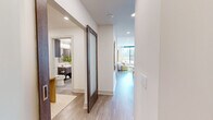 Located in Dallas, TX, this well-appointed 2-bedroom, 2-bathroom residence offers a thoughtfully designed single-floor layout with contemporary finishes throughout. The open-concept living room is anchored by expansive floor-to-ceiling windows that flood the space with natural light and frame sweeping city views, creating a bright and airy atmosphere. Light wood-tone flooring runs throughout, adding warmth and continuity between spaces.

The kitchen is a standout feature, showcasing rich dark wood cabinetry, a subway tile backsplash, stainless steel appliances including a gas range, a wall-mounted range hood, and a generous island with seating — ideal for both cooking and casual dining.

The primary bedroom is a comfortable retreat with large windows offering city views, a ceiling fan, and access to a spa-inspired en-suite bathroom complete with a soaking tub, a glass-enclosed shower with marble-style tile surround, a floating vanity, and direct entry to a spacious walk-in closet with custom shelving and dual hanging rods. The second bedroom is equally well-sized with ample natural light.

Additional highlights include a dedicated in-unit laundry room with a full-size Whirlpool washer and dryer, built-in cabinetry, and a hallway connecting all rooms seamlessly. Three closets provide exceptional storage throughout the residence.