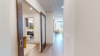 Located in Dallas, TX, this well-appointed 2-bedroom, 2-bathroom residence offers a thoughtfully designed single-floor layout with contemporary finishes throughout. The open-concept living room is anchored by expansive floor-to-ceiling windows that flood the space with natural light and frame sweeping city views, creating a bright and airy atmosphere. Light wood-tone flooring runs throughout, adding warmth and continuity between spaces.

The kitchen is a standout feature, showcasing rich dark wood cabinetry, a subway tile backsplash, stainless steel appliances including a gas range, a wall-mounted range hood, and a generous island with seating — ideal for both cooking and casual dining.

The primary bedroom is a comfortable retreat with large windows offering city views, a ceiling fan, and access to a spa-inspired en-suite bathroom complete with a soaking tub, a glass-enclosed shower with marble-style tile surround, a floating vanity, and direct entry to a spacious walk-in closet with custom shelving and dual hanging rods. The second bedroom is equally well-sized with ample natural light.

Additional highlights include a dedicated in-unit laundry room with a full-size Whirlpool washer and dryer, built-in cabinetry, and a hallway connecting all rooms seamlessly. Three closets provide exceptional storage throughout the residence.