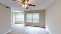 Located at 501 W Chatham St in Apex, NC, this single-floor residence offers a well-designed layout that balances comfort and functionality. The spacious living area is finished with light-toned wood-style flooring and features multiple windows dressed with white horizontal blinds, allowing ample natural light to fill the room. A ceiling fan with integrated lighting serves both the living space and additional rooms throughout the unit.

The galley-style kitchen is outfitted with white cabinetry, light granite-style countertops, and stainless steel appliances including a range, microwave, refrigerator, and dishwasher. Wood-style flooring continues through this space, and overhead fluorescent lighting ensures the area is well-lit for meal preparation.

The bedroom features plush carpeting and benefits from dual reach-in closets, providing generous storage capacity. A window with blinds brings in natural light, while a ceiling fan adds comfort. A secondary room with warm wood-style flooring also includes a ceiling fan and private door access.

The full bathroom is cleanly appointed with a single-sink vanity featuring white cabinetry, a combination tub and shower, and wood-style flooring. Neutral warm-gray tones are carried throughout the unit, contributing to a cohesive and inviting atmosphere across all rooms.