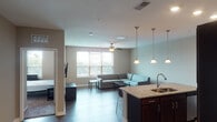 Located in Stillwater, Oklahoma, this single-floor unit offers a thoughtfully designed open-concept layout that seamlessly connects the kitchen, dining, and living areas. The kitchen is a standout feature, outfitted with rich dark-wood cabinetry, granite countertops, stainless steel appliances including a range, microwave, and refrigerator, and a large peninsula with bar seating illuminated by elegant pendant lighting. Wood-style flooring runs throughout the main living areas, adding warmth and continuity to the space.

The living room is bright and welcoming, with large windows that invite abundant natural light and views of the surrounding landscape. A ceiling fan adds both function and comfort to the area. The open sightlines from the kitchen to the living room create an ideal layout for everyday living.

Multiple bedrooms provide comfortable private retreats, each featuring ceiling fans, carpeted floors, and windows that bring in natural light. Closet storage is available in the bedrooms, and the neutral wall tones create a calm, versatile atmosphere.

The bathroom is clean and functional, equipped with a shower-tub combination, a single-sink vanity with dark wood cabinetry, and a well-lit mirror. Overall, the unit presents a modern, practical living environment suited for a range of occupants.