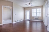 Located at 1606 Prairie Pl in Holmen, WI, this two-bedroom, two-bathroom single-floor residence offers a well-designed layout with a comfortable and functional living environment. The open-concept main area seamlessly combines the living room, dining room, and kitchen, all finished with rich hardwood-style flooring. The kitchen is a standout feature, equipped with white cabinetry, stainless steel appliances, a granite-topped island with pendant lighting, and recessed ceiling lights, making it both practical and visually appealing. The living area benefits from natural light through large windows and a ceiling fan, with a glass-panel door providing direct access to the private balcony overlooking open surroundings. Both bedrooms are carpeted for comfort and include ceiling fans and windows with outdoor views. The primary bedroom is generously sized and accompanied by an en-suite bathroom. The bathrooms feature tile flooring, white vanity cabinetry, and warm countertops. A dedicated in-unit laundry room with wire shelving accommodates a full-size washer and dryer. Three closets provide ample storage throughout. The neutral warm-toned walls and consistent finishes create a cohesive and inviting atmosphere throughout the home.