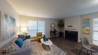 This single-floor unit offers a well-designed layout that balances comfort and functionality across its main living spaces. The living room serves as the centerpiece, featuring rich dark hardwood-style flooring, a classic white-mantled fireplace, and large windows with horizontal blinds that allow ample natural light to fill the room. The open, airy feel is complemented by neutral-toned walls throughout.

The dining area connects seamlessly to the kitchen via a pass-through window, promoting an open flow between spaces. The kitchen is equipped with white cabinetry, granite-style countertops, dark appliances, and a bright window that brings in additional natural light.

The unit includes two bedrooms, both carpeted for warmth and comfort. The primary bedroom features a door that opens to an outdoor area, while the secondary bedroom offers a cozy, well-proportioned space suitable for various uses.

The bathroom is finished with white cabinetry, a granite-style vanity countertop, a large mirror with overhead lighting, and a shower-tub combination. Dark hardwood-style flooring extends through the main living and dining areas, tying the space together with a cohesive, contemporary aesthetic.