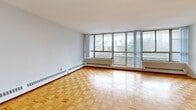 Located at 35-49 Thorncliffe Park Dr in Toronto's Thorncliffe Park neighbourhood, this well-appointed 2-bedroom, 2-bathroom unit offers a generous and functional layout across a single floor. The living areas are highlighted by classic parquet hardwood flooring and expansive floor-to-ceiling windows that flood the space with natural light while framing open city views. The bright and spacious living room provides ample room for relaxing and entertaining, benefiting from a wide window wall that further enhances the airy feel. The galley-style kitchen is efficiently designed with white cabinetry, taupe countertops, a stainless steel sink, and light vinyl plank flooring, providing practical storage and workspace. The primary bedroom is generously proportioned, featuring parquet flooring, a large window with outdoor views, and baseboard heating. The second bedroom is equally well-lit with its own window and parquet flooring. A dedicated walk-in closet with built-in hanging rods offers excellent storage. Two bathrooms serve the unit — one featuring a full bathtub with tile surround and mosaic tile flooring, and the other a functional three-piece layout. Two hallways connect the spaces seamlessly, completing this comfortable and practical home.