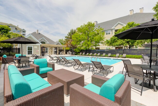 View of pool with soft seating, loungers, tables and umbrellas - Hawthorne Commons