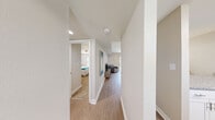 Located at Colony Square Court in Newport News, Virginia, this single-floor residence offers a clean, contemporary design with a neutral color palette throughout. The open hallway connects the main living areas, featuring light wood-style flooring that flows seamlessly from room to room.

The kitchen is well-appointed with crisp white shaker cabinetry, granite-style countertops, and a full suite of stainless steel appliances including a refrigerator, dishwasher, electric range, and built-in microwave. A window above the sink allows natural light to brighten the workspace.

The living room is a comfortable and airy space anchored by large sliding glass doors that open to a view of a landscaped outdoor area, filling the room with natural light. The bedrooms feature plush carpeting, ceiling fans with light fixtures, and ample storage provided by sliding-door closets and built-in shelving. The bathroom is finished with a white vanity, large mirror, and clean, bright fixtures.

Overall, the space presents a well-maintained, functional layout with consistent modern finishes, making it a practical and comfortable residence in Newport News.