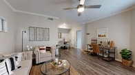 Located at 1822 Barker Cypress Rd in Houston, TX, this thoughtfully designed one-bedroom, one-bathroom residence offers a functional and cohesive single-level layout. The open-concept living area welcomes you with crown molding, neutral toned walls, and durable hardwood-style flooring that flows throughout the main living spaces. A ceiling fan overhead and a dedicated workspace nook add both comfort and practicality. A sliding glass door fills the living area with natural light and provides direct outdoor access.

The adjoining dining area comfortably accommodates a round table for four and transitions seamlessly into the galley-style kitchen. The kitchen features white shaker cabinetry, light countertops, a mosaic tile backsplash, and a full suite of stainless steel appliances including a refrigerator, range, microwave, and dishwasher.

The spacious primary bedroom is carpeted for comfort, includes a ceiling fan, and receives ample natural light through a large window. A dedicated closet provides generous storage. The full bathroom is finished with white cabinetry, a single vanity with a wide mirror, stylish pendant lighting, and a shower-tub combination — all presented in a clean, bright aesthetic.