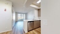 This contemporary 570 square foot apartment in Marina Del Rey showcases a thoughtful design that maximizes space and functionality. The open-concept living area seamlessly integrates the kitchen, dining, and living spaces, creating a sense of spaciousness. The kitchen is a highlight, boasting clean lines with light-toned cabinetry, quartz countertops, and a full suite of stainless steel appliances, including a gas range and built-in microwave.

The bedroom, measuring 150 square feet, offers a tranquil retreat with large windows that flood the space with natural light. A curved window bay adds architectural interest and expands the views. The bathroom features a modern aesthetic with a combined tub and shower, adorned with sleek white tiles and complemented by warm wood-look flooring.

Throughout the apartment, engineered hardwood floors in a light oak finish contribute to the bright, airy ambiance. Large windows in every room, including sliding glass doors leading to a private balcony, offer stunning urban vistas and fill the space with abundant natural light. The neutral color palette of whites and light woods creates a versatile canvas for various decor styles, while track lighting adds a contemporary touch to the overall design.